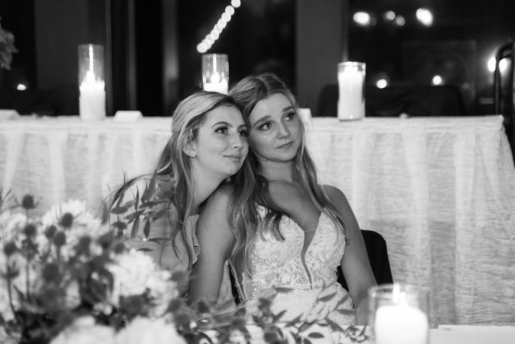 The bride and her sister tearfully watching the groom dance with his grandma