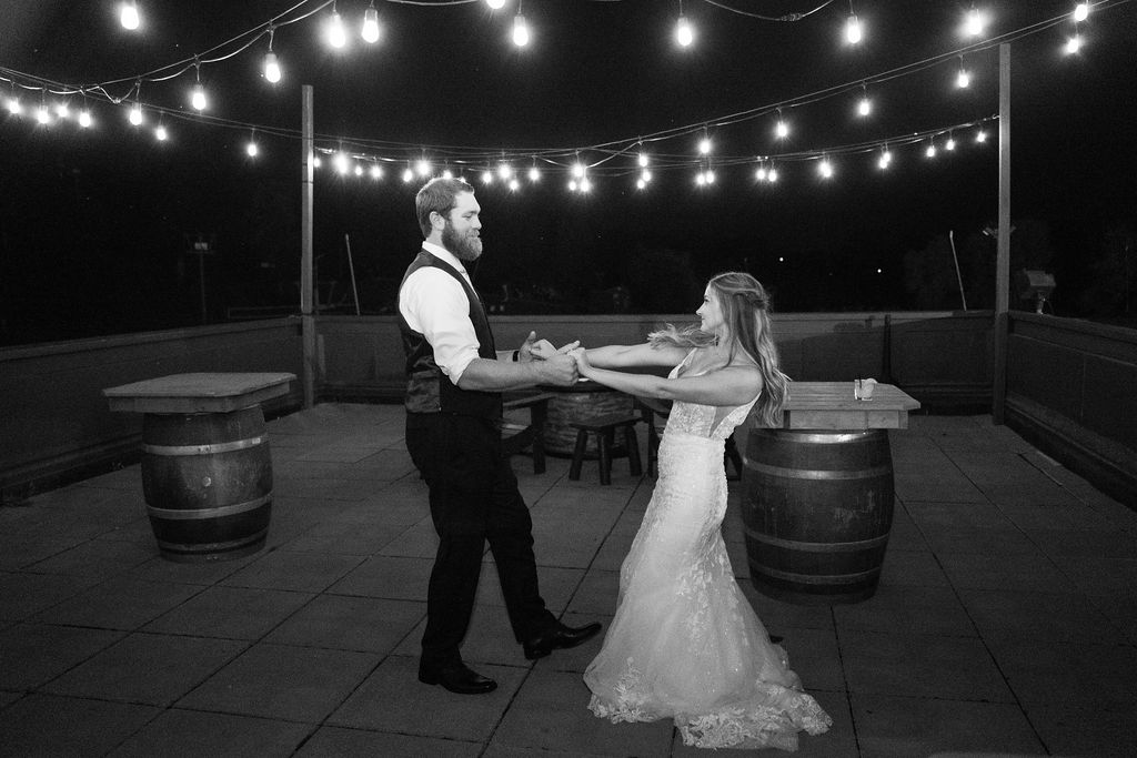 Bride and groom dancing under strung lights at night